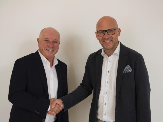 Ein Handschlag als Symbol der langfristigen Partnerschaft: Dr. Michael Schineis (l.), Wintersport-Chef bei Amer Sports, Klaus Dittrich, CEO der Messe München.