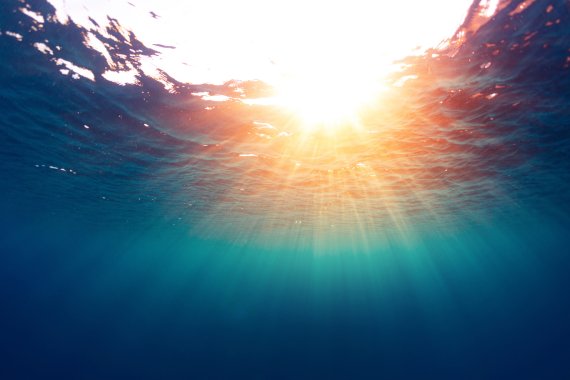 Unterwasseraufnahme: Sonnenstrahlen scheinen durchs Wasser