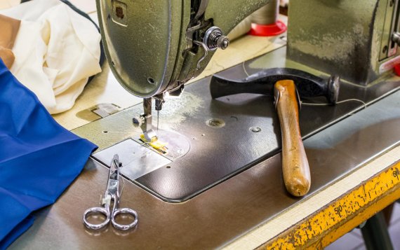 Einfach Kleidung nähen: Nähmaschine, Schere und Hammer zur Bekleidungsreparatur.
