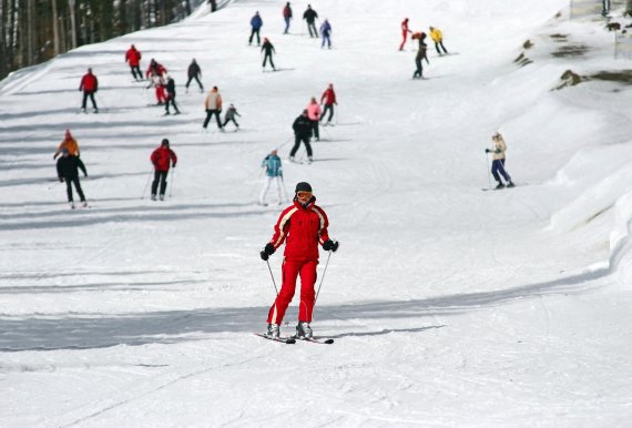 Eine Frau fährt auf Ski einen Hügel hinunter