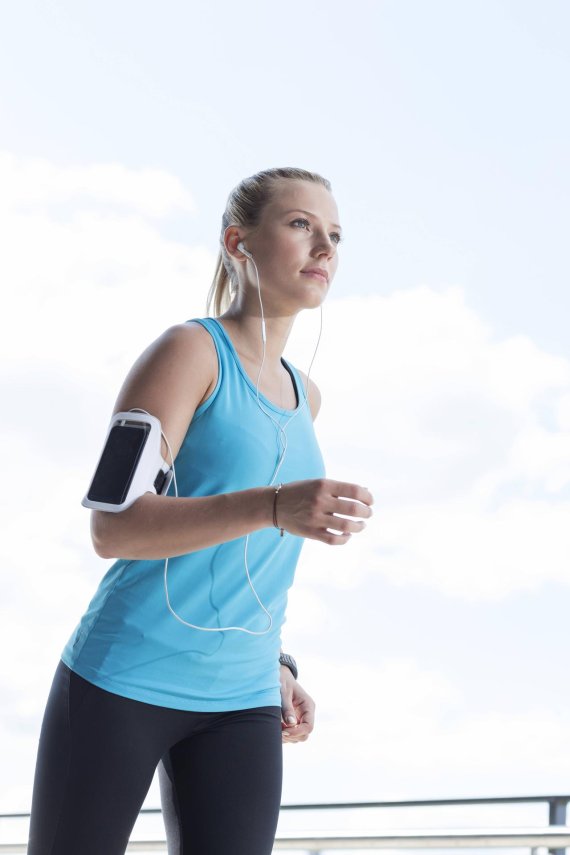 Eine junge Frau joggt mit Smartphone