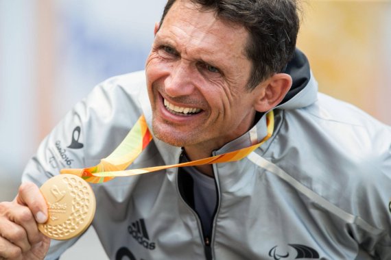Michael Teuber präsentiert überglücklich seine Goldmedaille von Rio 2016.