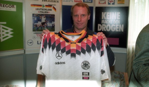 Bundestrainer Berti Vogts präsentiert das Trikot der deutschen Nationalmannschaft für die WM 1994. Der Ansatz einer stilistischen Fortsetzung der 1990er Trikots ging ziemlich in die Hose - ebenso wie die WM. Im Viertelfinale war gegen Bulgarien Schluss. 