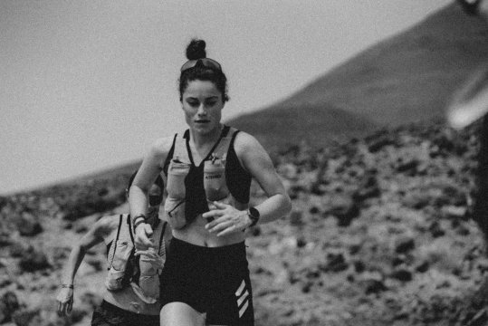Trailrunnerin Kimi Schreiber beim Laufen in Berglandschaft