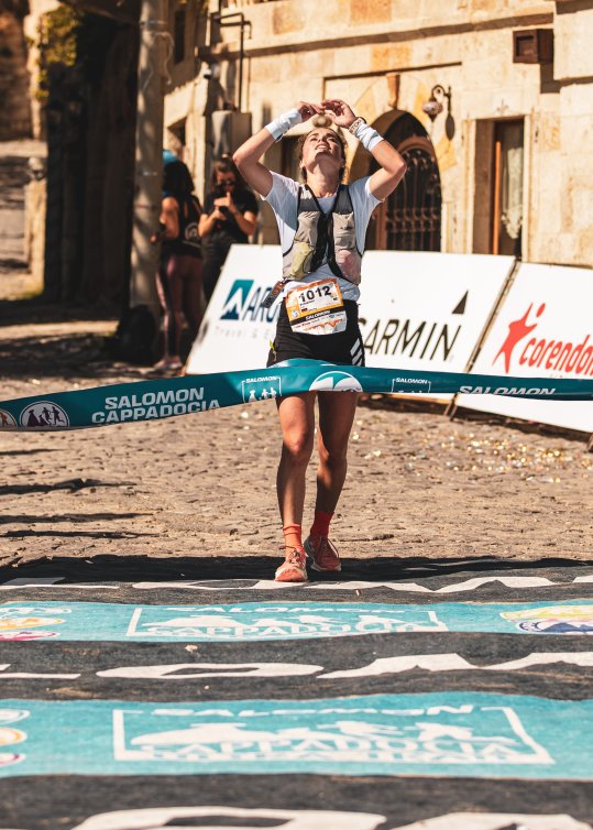Trailrunnerin Kimi Schreiber bei ihren Sieg in Cappadocia, die Medaille küssend 