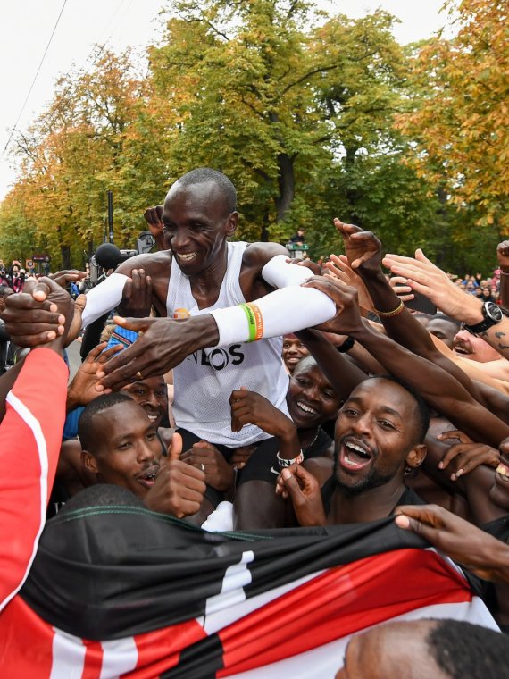 Behind the finish line, Eliud Kipchoge celebrates with his team.