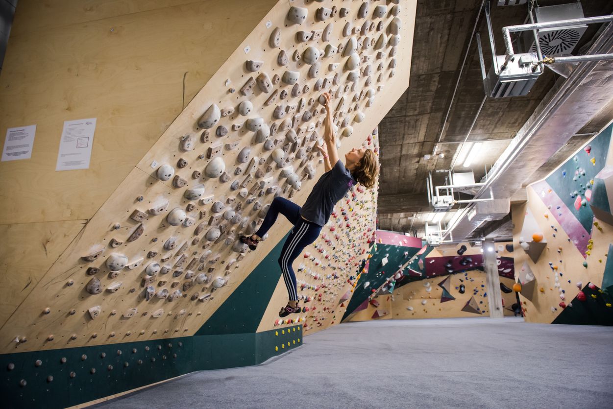 Basement Boulderstudio Frau klettert an einer Kletterwand im Basement Boulderstudio