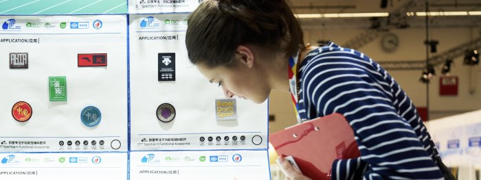 Besucherin der ISPO betrachtet Materialien in der Textrends Area