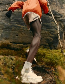 Person joggt, trägt orangene Jacke