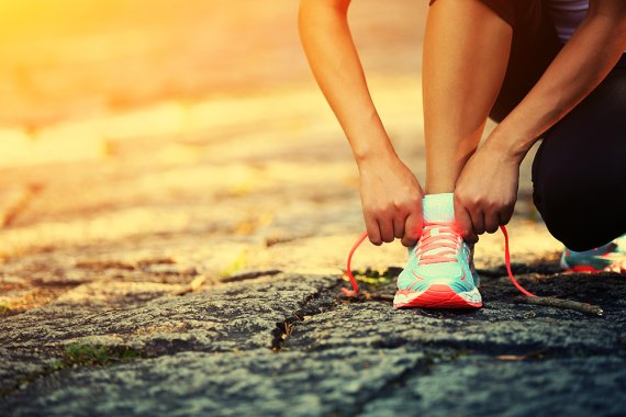 Runners and joggers will find a wide selection of running shoes today Woman ties bow in running shoe