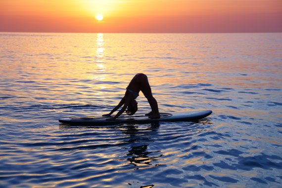 SUP-Yoga fördert die Konzentration und das Gleichgewicht. Denn hierbei werden die Übungen auf dem Wasser auf einem Surfbrett durchgeführt. Wer mit den Gedanken abschweift oder nicht bei der Sache ist, riskiert einen Fall ins kühle Nass.