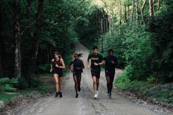 Vier junge Menschen beim Laufen im Wald 