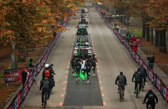 Eliud Kipchoge (white jersey) in the middle of his pacemakers chasing the green laser mark - and thus the record.