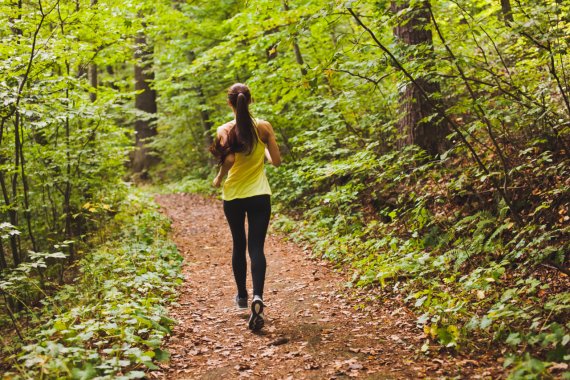 Frau joggt auf einem Weg im Wald