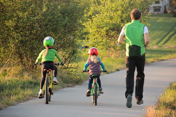 Gemeinsam bewegen, Stress abbauen: Die Eltern joggen, die Kindern nehmen das Fahrrad.