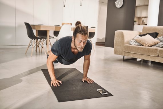Die Zahl der Nutzer mobiler Trainings-Apps ist im Corona-Jahr 2020 rapide gestiegen. Mann macht Liegestütze