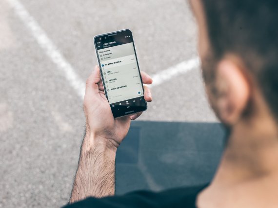 Schnelle Infos und Daten zum kleinen Preis dank KI und Fitness-Apps Mann schaut auf sein Smartphone