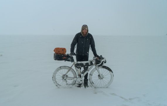 Jonas Deichmann mit seinem Fahrrad im Schnee Schnee Foto von Jonas Deichmann