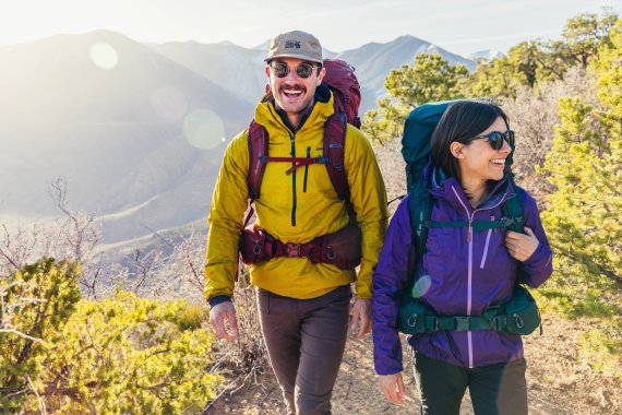 Zwei Erwachsene wandern im Sonnenschein