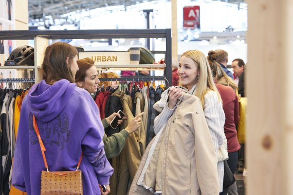 Tres mujeres en el stand de Vaude en ISPO Munich 2023. 