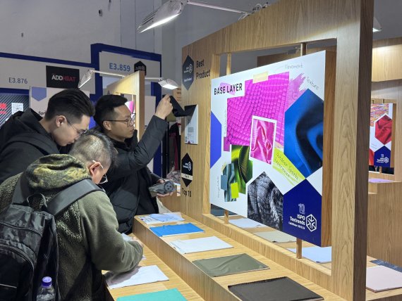 Les gens s'intéressent aux tendances textiles à ISPO Beijing 2024.