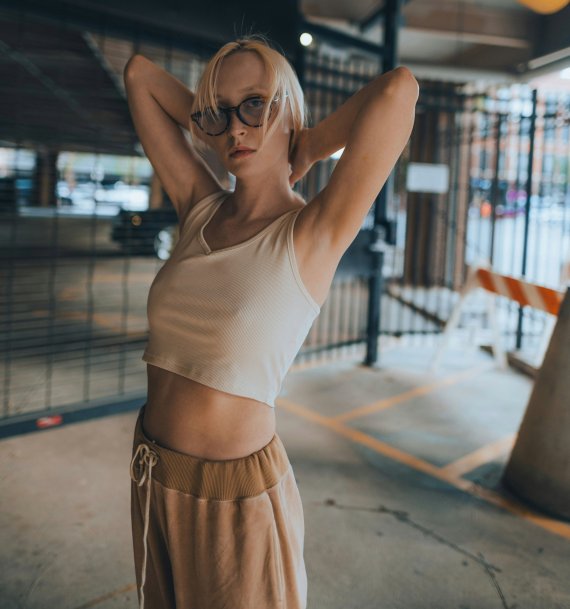 Young woman wearing athleisure clothes Young woman in athleisure clothes standing in a moody urbanparking garage