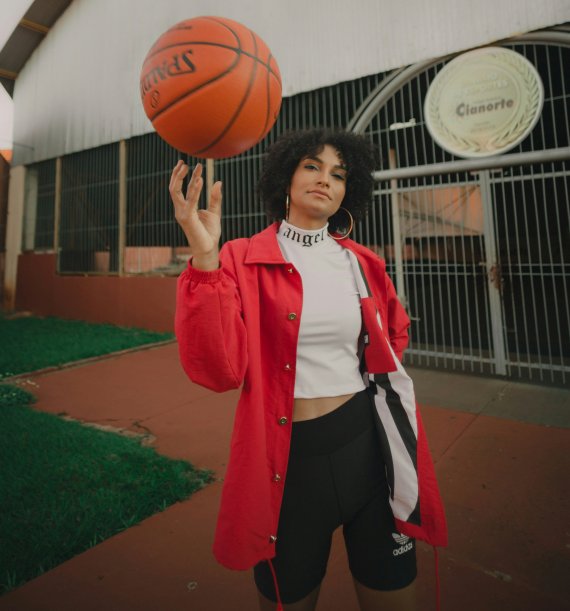 Woman in athleisure clothes Young woman wearing athleisure clothing spinning a basketball