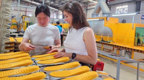 Zwei Frauen sehen sich die Produktion von Einlagesohlen an 