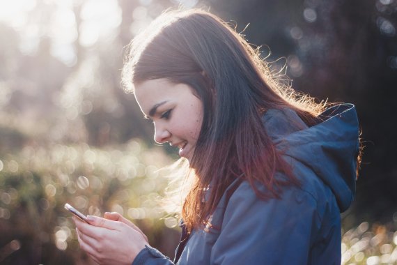 Junge Dame im Wald mit Smartphone