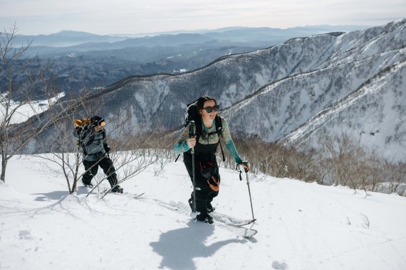 Zwei Menschen bewandern einen verschneiten Wanderweg