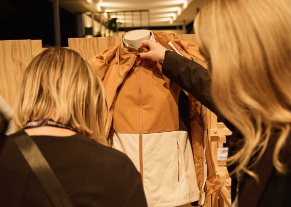 Zwei Frauen schauen sich eine Jacke eines ISPO Award 2024 Gewinners an