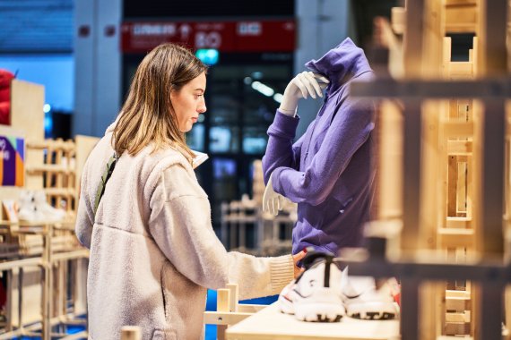 Frau auf der ISPO 2024 schaut sich Jacke an