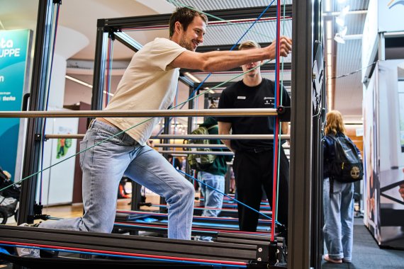 Mann probier Sportgerät auf der ISPO 2024 aus