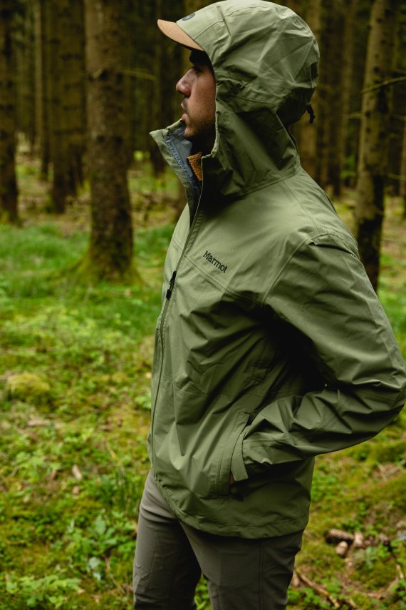 Person mit grüner PreCip Evo Flex Jacke von Marmot im Wald