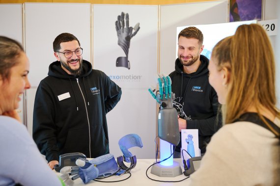 ISPO Aussteller stehen vor einer mechanischen Hand