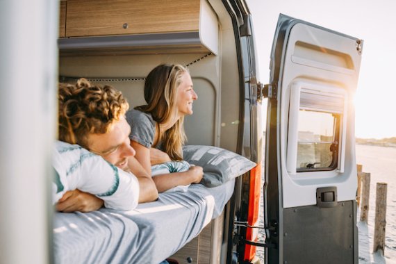 Zwei Personen in einem Van beim Campen