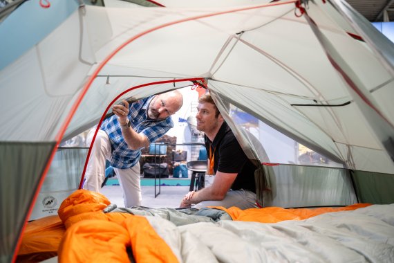 Zwei Outdoor begeisterte Personen schauen sich ein Zelt auf der OutDoor by ISPO 2024 an