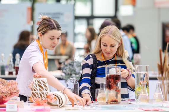 Zwei Outdoor begeisterte Besucherinnen schauen sich nachhaltige Materialien für das Sport Business auf der OutDoor by ISPO 2024 an