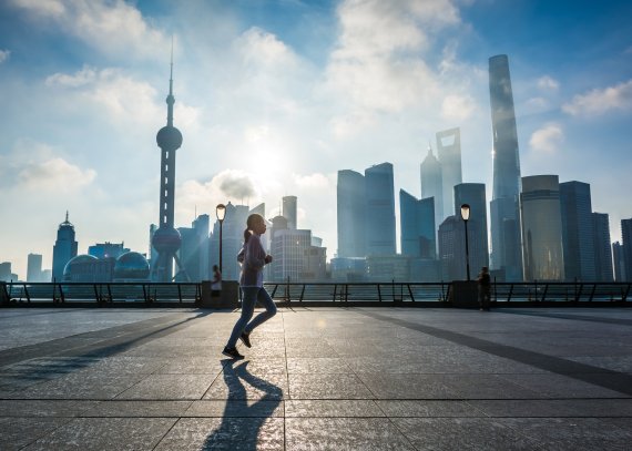 Frau mit Sprotbekleidung joggt entlange des Bund in Shangai.