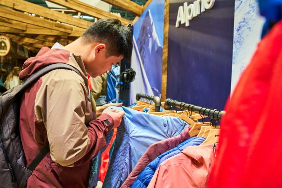 Besucher der ISPO 2024 schaut sich innovative Sportbekleidung an