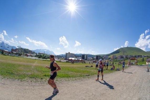 Runners in bright sunlight during Alpe d'Huez triathlon.