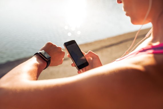 Woman taking a look at her wearable and smartphone