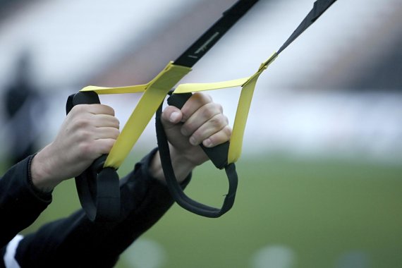 TRX Hände greifen einen TRX Schlingentrainer