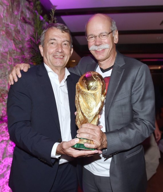 Dieter Zetsche (r.) hält in der Nacht des WM-Triumphs in Brasilien gemeinsam mit dem damaligen DFB-Präsidenten Wolfgang Niersbach den Weltmeister-Pokal.