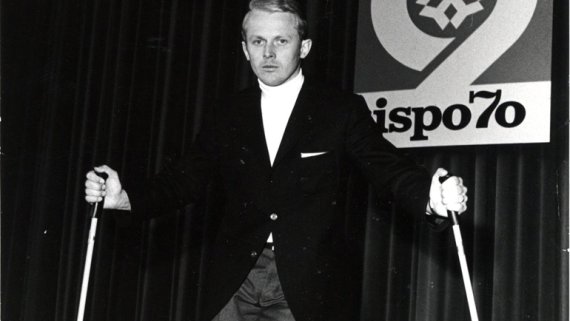 Am 8. März 1970 öffnet die ISPO Munich ihre Tore. Schwarz weiß Bild von Mann mit Skistöcken auf der Bühne der ISPO 1970.