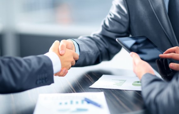 Win new partners and customers at ISPO Munich. Two men in business clothes shake hands.