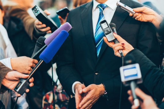 A man in a suit answers questions of journalists A man in a suit answers questions of journalists