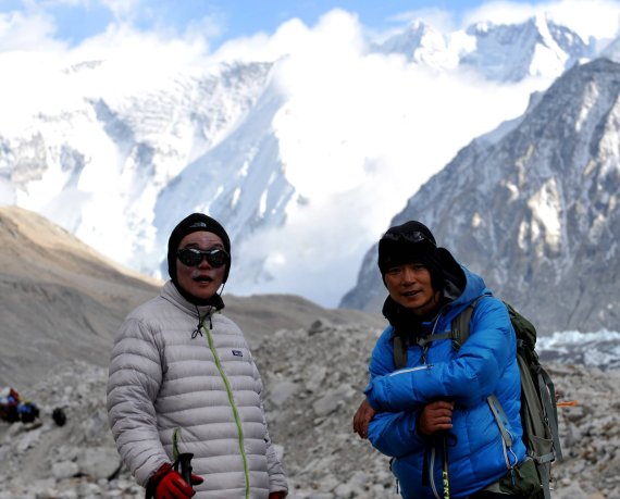 Two asian men standing in front of mountains in the Himalaya. 