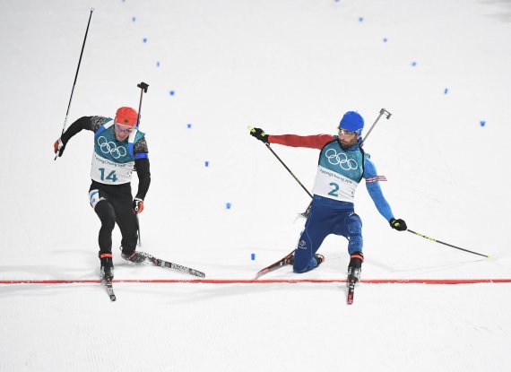 The photo finish decides: Only one foot tip separates Simon Schempp (l.) from the gold medal. At the end of the mass start over 15 kilometres Martin Fourcade is 18 thousandths of a second faster (or 14 centimetres ahead) - and Olympic Champion. 