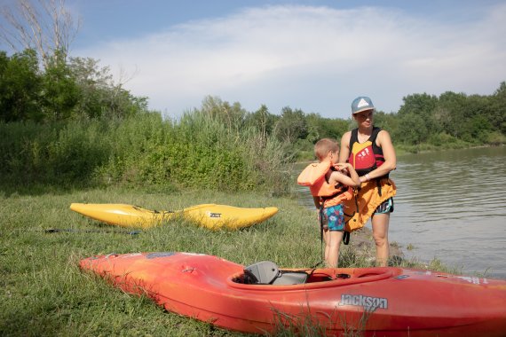 Freestyle kayaker Nina Csonkova helps her five-year-old son to put on his life jacket 